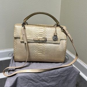 Brahmin purse with short handle on top or strap to be worn on shoulder.